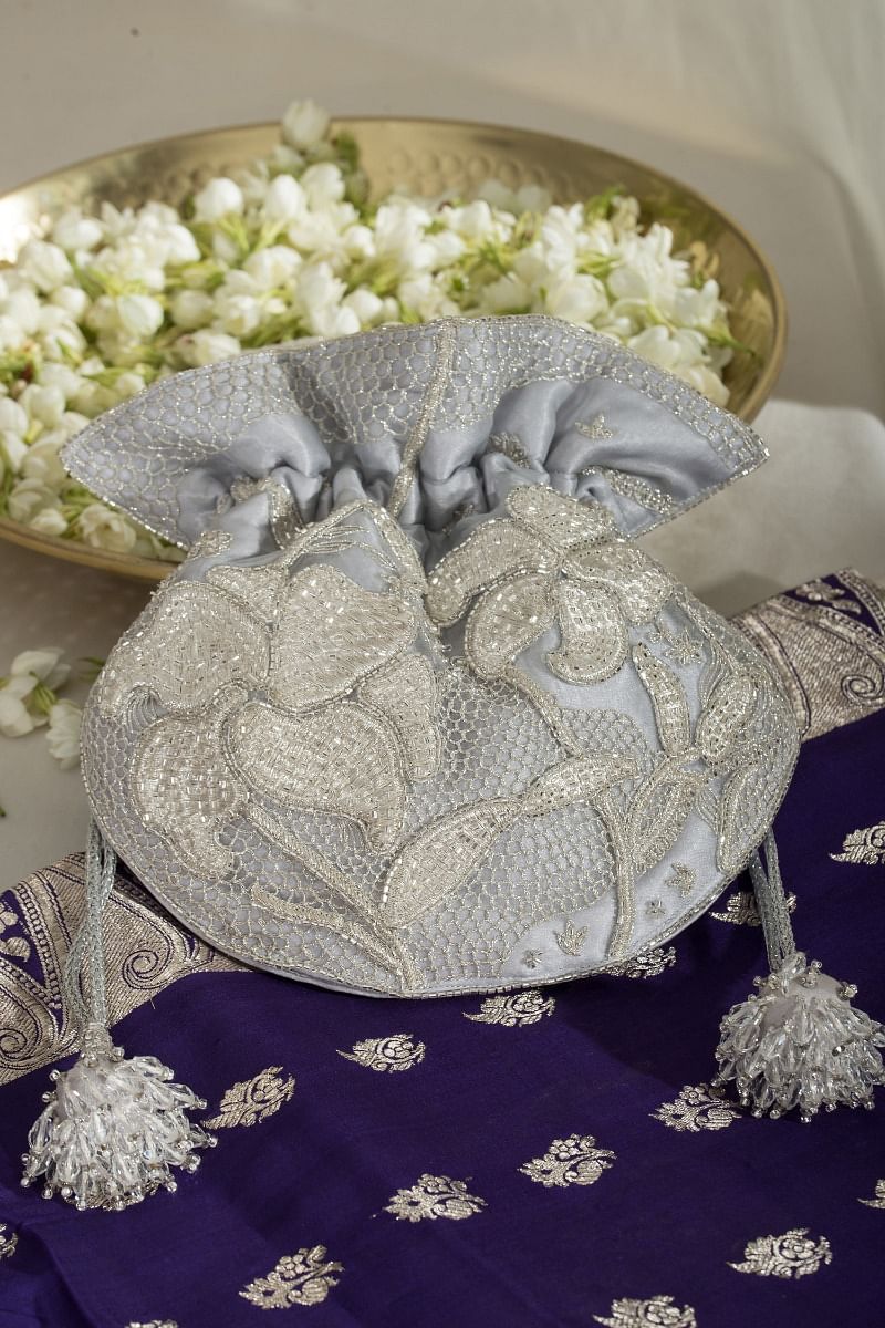 Buy Silver floral zari embroidery potli bag by Ozel at Aashni and Co