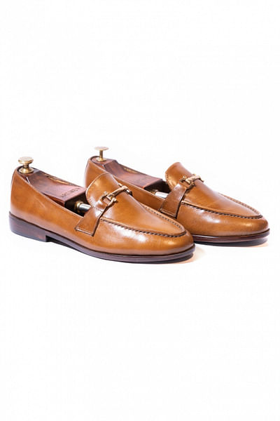 Tan buckle accented loafers