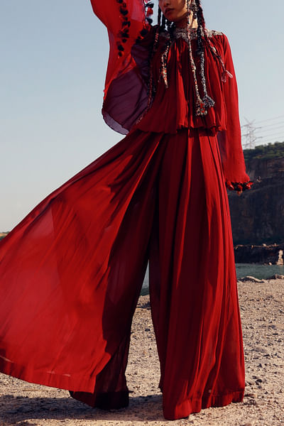Red asymmetrical top and flared pants