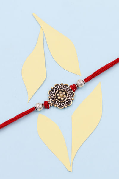 Red and gold embellished thread rakhi