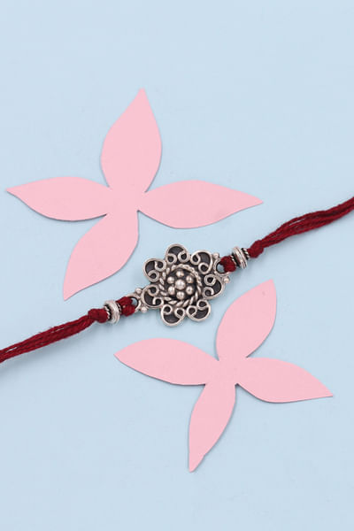 Silver and maroon floral thread rakhi