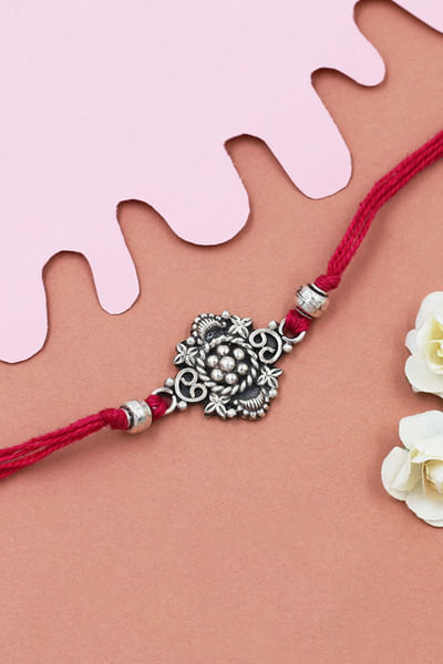 Silver and red embellished thread rakhi