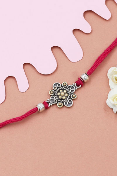 Silver and red floral thread rakhi