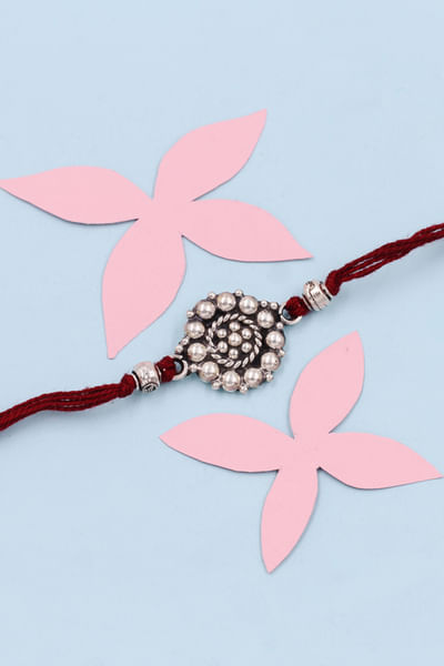 Silver circular embellished thread rakhi