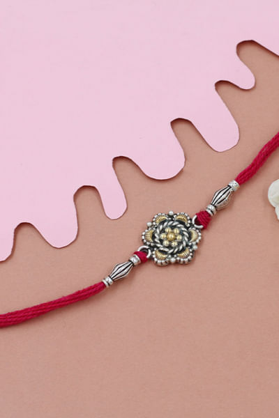 Silver floral thread rakhi