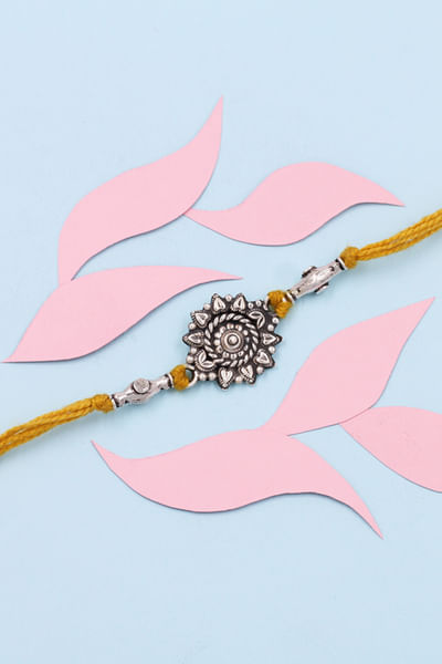 Silver floral thread rakhi