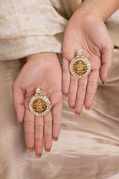 Gold goddess motif earrings