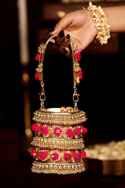 Gold pom-pom and bead embellished bucket bag