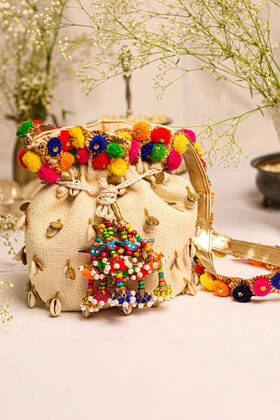 Off-white shell and pom-pom tasselled potli