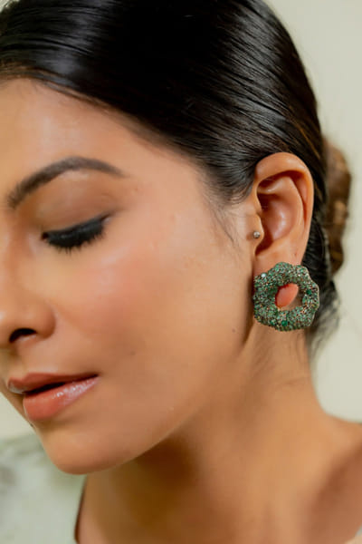 Gold and emerald stone embellished earrings